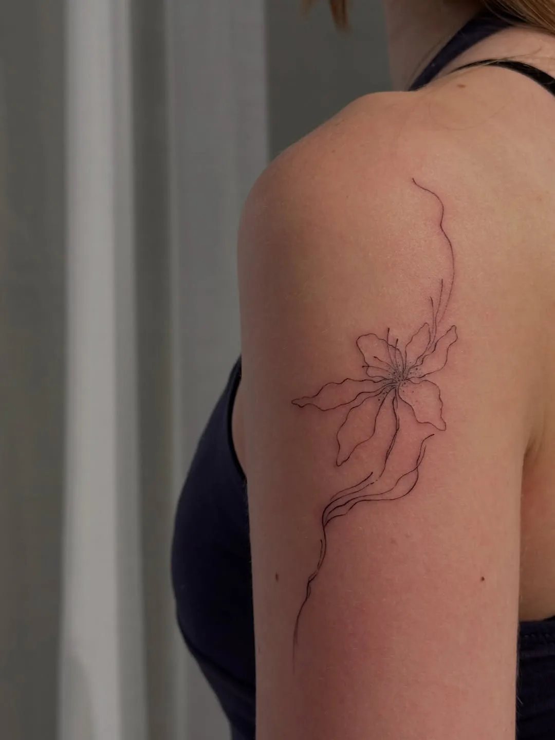 Abstract flower fine line tattoo on shoulder — Aroa Sinkply Zürich