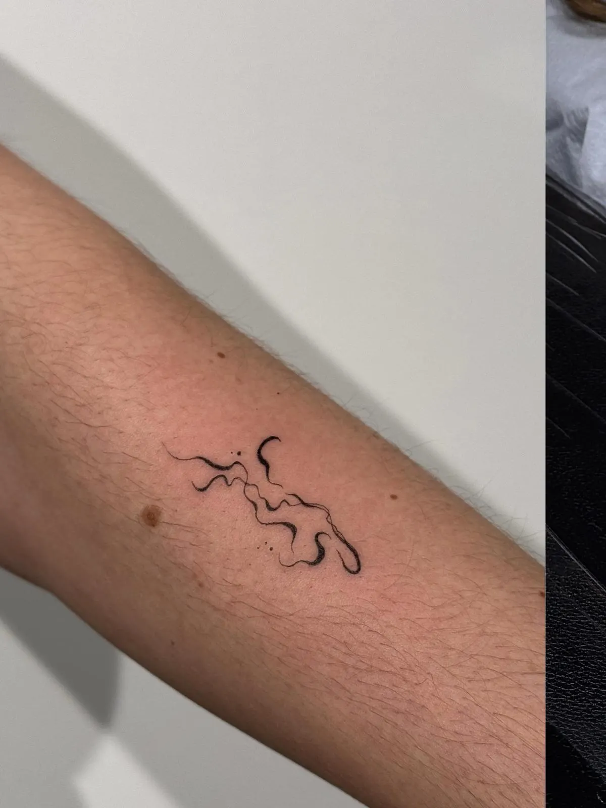 Abstract Wellenlinien Kalligraphie Tattoo am Arm — Sinkply Zürich