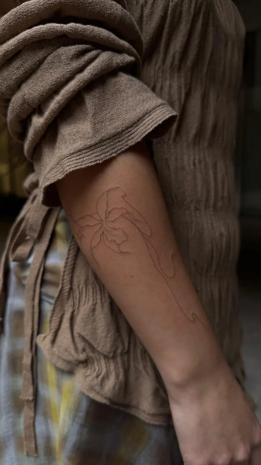 Iris and orchid fine line tattoo upper arm