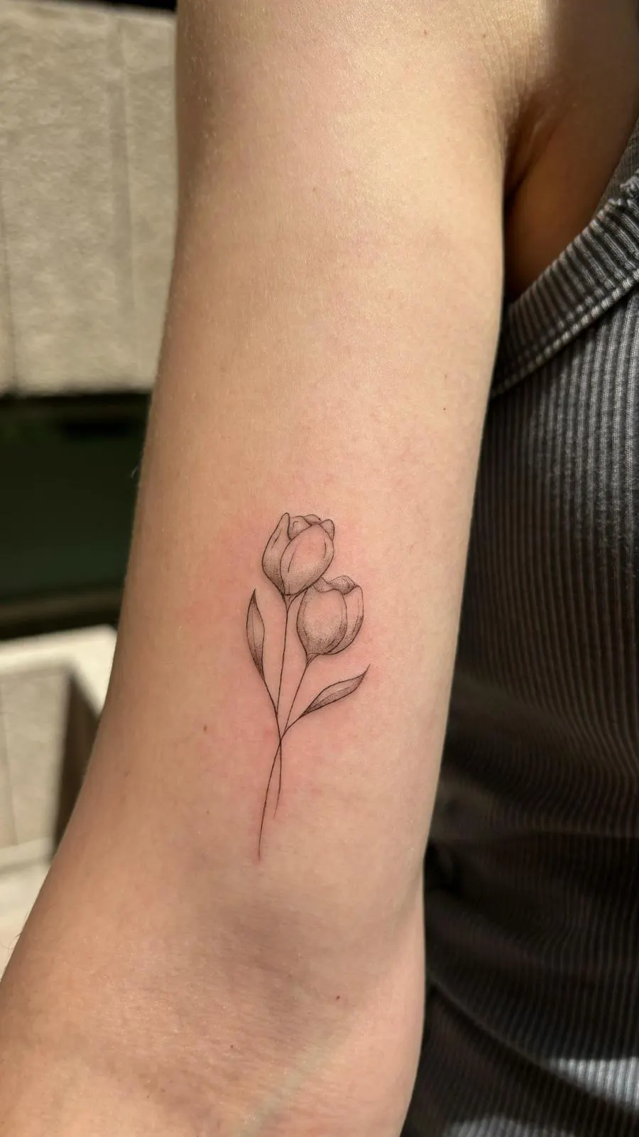 Botanical fine line tulip tattoo on upper arm — Sinkply Zürich