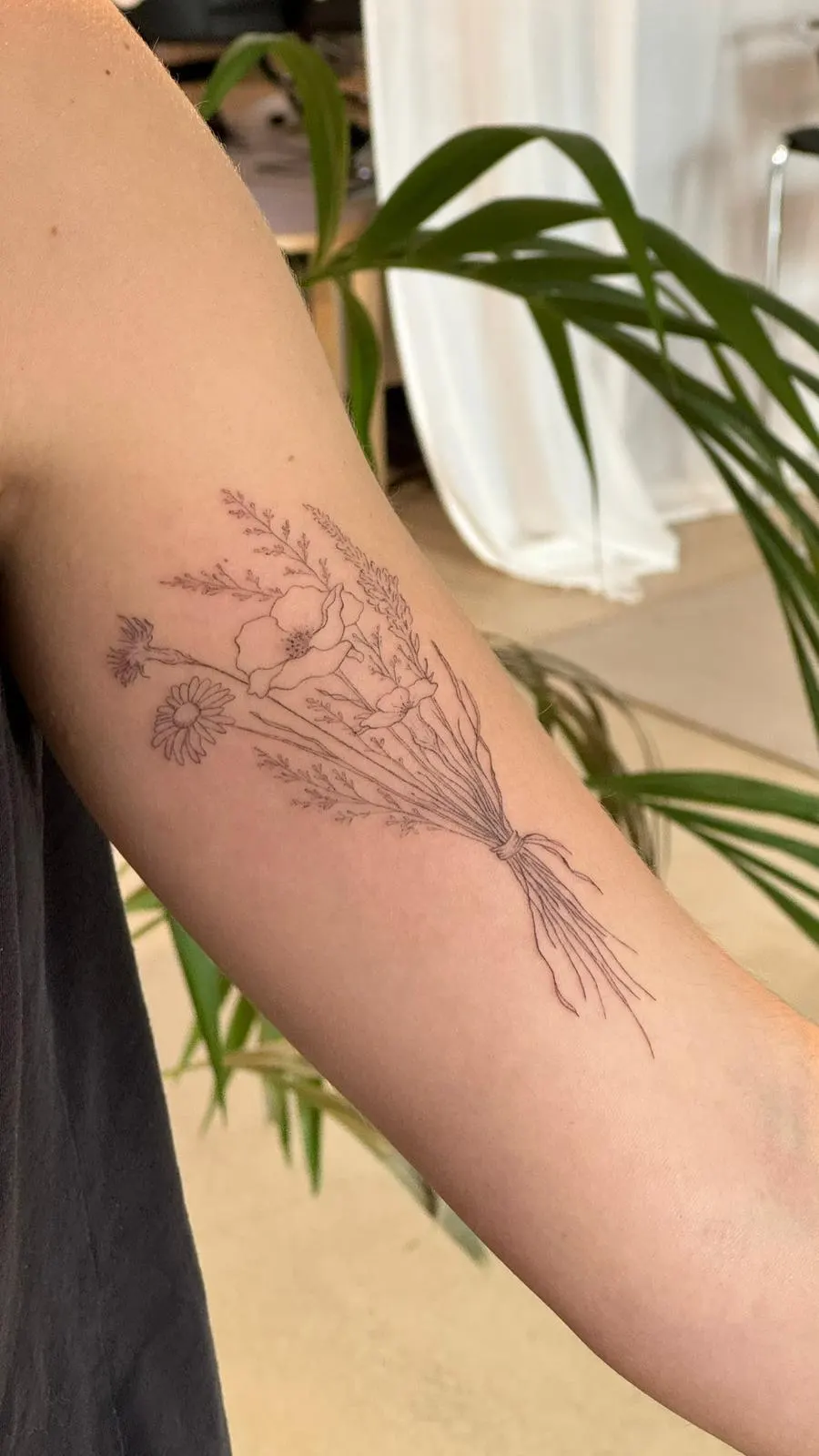 Wildflower bouquet fine line tattoo upper arm Sinkply Zürich