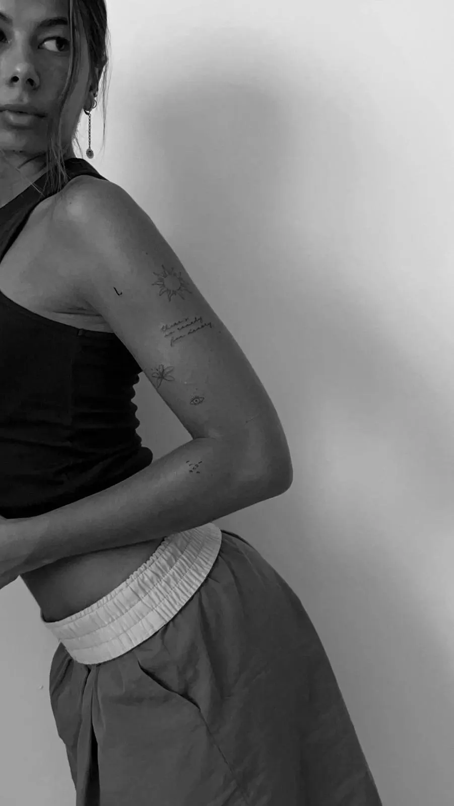 Editorial woman with fine line tattoo collection on arm black and white Sinkply Zürich