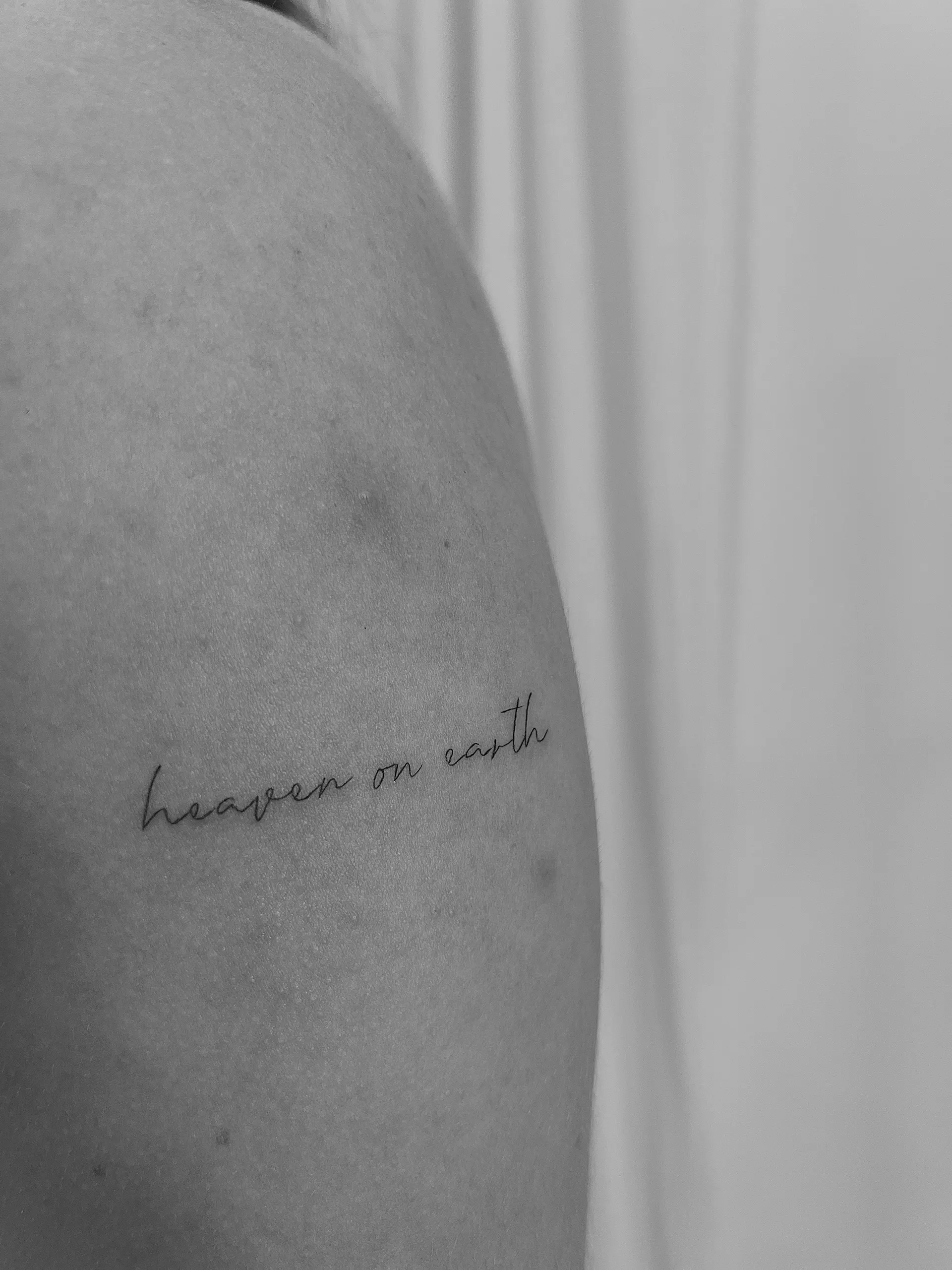 Heaven on Earth lettering shoulder tattoo