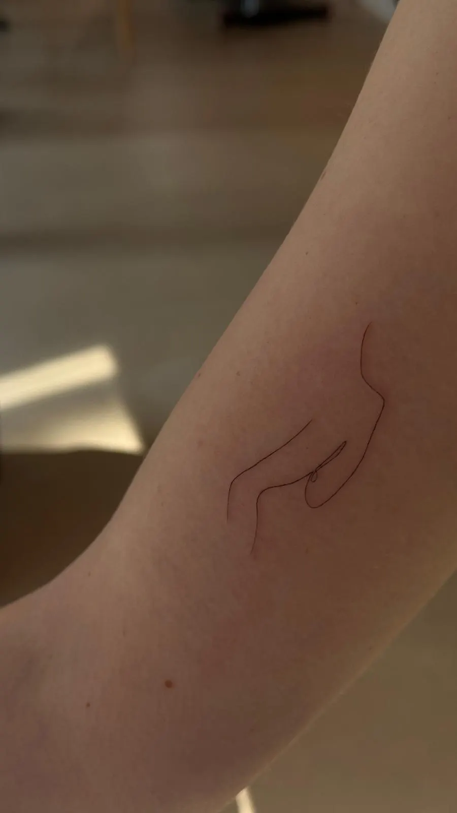 Single line hand silhouette minimal fine line tattoo on arm